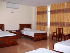 a bedroom with four beds and a window with curtains at Bank Star Hotel in Ðố Sơn +11 photos