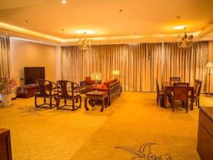 a living room with a couch and a table and chairs at Erdos Great Gate Hotel in Hantai