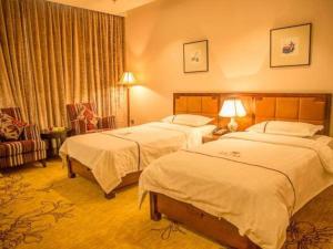 a hotel room with two beds and a chair at Erdos Great Gate Hotel in Hantai +129 photos