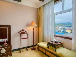 1 dormitorio con ventana, mesa y lámpara en Shangri-la Zhaxidele Hotel, en Shangri-La