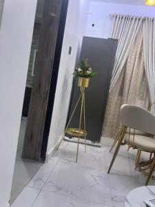 a room with a table and chairs and a black door at Clare Apartment 1BR modern flat in Abuja