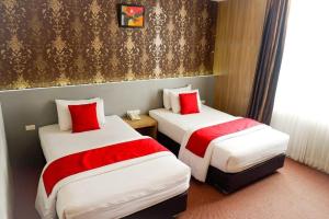 LamglumpangHotel Mekkah Banda Aceh的两张位于酒店客房的床铺,配有红色枕头 更多133张照片
