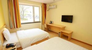 una habitación de hotel con dos camas y un escritorio en 7 Days Inn Tianjin West Station Commercial Unversity, en Tianjin 65 fotos más