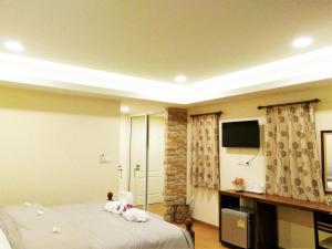 two stuffed animals sitting on a bed in a room at The Vintage Residence in Ban Thung Sukla +42 photos