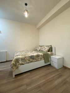 a white bedroom with a bed and a night stand at Avlabari Inn - The coziest place in Tbilisi City