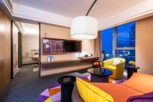 a living room with a couch and a tv at Hampton by Hilton Suzhou XiangCheng in Suzhou