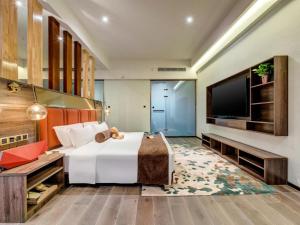 a hotel room with a bed and a flat screen tv at James Joyce Coffetel·Anyang Text Museum in Anyang