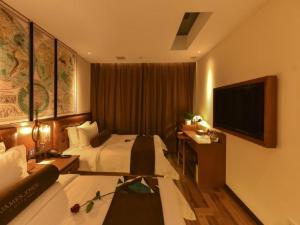 a hotel room with a bed and a flat screen tv at James Joyce Coffetel·Beijing Yizhuang Development Zone Dazu Square Tongji Road in Beijing