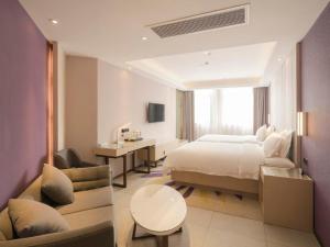 a hotel room with a large bed and a desk at Lavande Hotel·Tianmen Xincheng in Tianmen