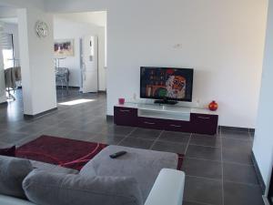 a living room with a couch and a flat screen tv at Villa Vellutini in Calvi