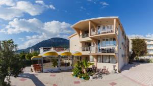 a large white building with yellow awnings at Villa Jadran Apartments in Bar