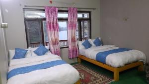 Postel nebo postele na pokoji v ubytování Hotel Jharana