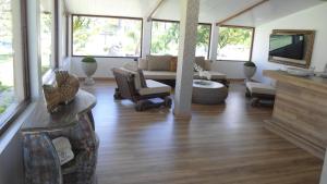 a living room with a couch and a tv at Fazenda Fiore Resort in Paripueira