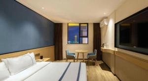 a hotel room with a bed and a table and a window at City Comfort Inn Guilin Two Rivers and Four Lakes Sun and Moon Shuangta in Guilin