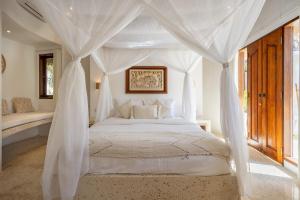 Un dormitorio con una cama blanca con dosel. en Island Bungalow in Perfect Location Bingin Bali, en Uluwatu
