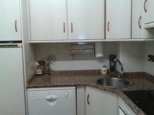a kitchen with white cabinets and a sink at Can Mestre in Cambrils