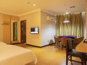 a hotel room with a bed and a dining room at Borrman Hotel Dongguan Zhongtang in Dongguan