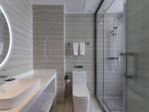 a bathroom with a toilet and a sink and a shower at Xana Hotelle Ulanqab Municipal Government Wanda Plaza in Jining +270 photos