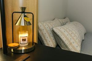 a candle on a table in front of a mirror at Be Staycation Sai Gon in Ho Chi Minh City +76 photos
