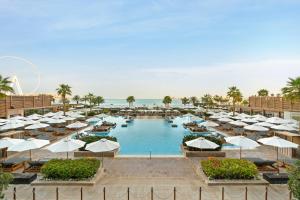 um resort com uma piscina com guarda-sóis e o oceano em Rixos Premium Dubai JBR no Dubai