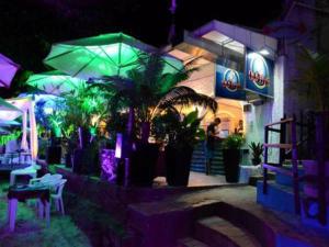 a restaurant with plants and umbrellas at night at Flat Vila 4 Amigos in Natal