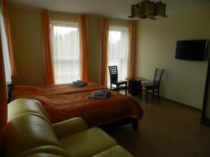 1 dormitorio con cama, sofá y mesa en Greta, en Druskininkai