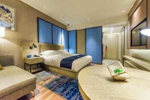 a hotel room with a large bed and a table at Echarm Hotel Qianxi High Speed Railway Station in Qianxi +275 photos