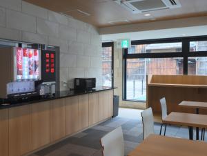 a restaurant with a counter and tables and chairs at Hotel Glad One Kyoto Shichijo by M's in Kyoto