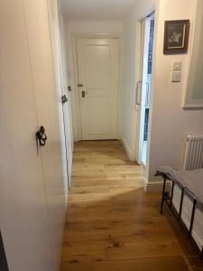 a hallway with a white door and a wooden floor at East Dulwich - double room with en suite in London