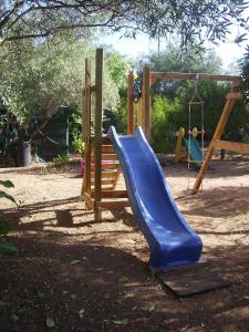 a playground with a blue slide and a swing at Villa Arancio Giorgio in Cala Liberotto