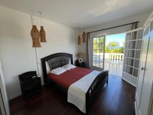 Saint-PaulにあるVilla Mahé 8 personnes avec piscine et vue merのベッドとガラスの引き戸のある寝室 +26枚の写真