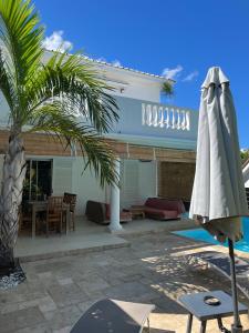 Saint-PaulにあるVilla Mahé 8 personnes avec piscine et vue merの家の隣のパティオ(傘付)