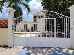 a white gate in front of a house at Casa Caribe in Bacalar