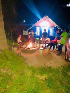 a group of people standing around a fire in front of a house at Vintage Breeze Home Stay in Madikeri