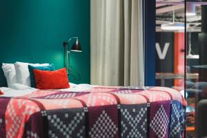 1 dormitorio con 1 cama con manta roja y blanca en Bo Hotel en Estocolmo
