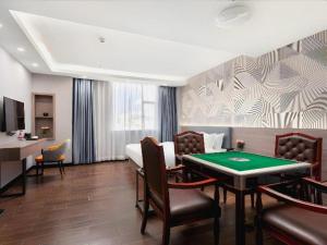 a hotel room with a pool table in a room at Borrman Hotel Huizhou Danshui High-speed Railway Huiyang Station in Huizhou