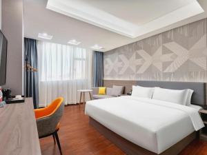 a bedroom with a large white bed and a couch at Borrman Hotel Huizhou Danshui High-speed Railway Huiyang Station in Huizhou +113 photos