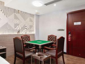 a poker table and chairs in a room with a table at Borrman Hotel Huizhou Danshui High-speed Railway Huiyang Station in Huizhou