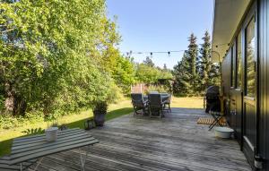 une terrasse en bois avec une table et des chaises dessus dans l'établissement Gorgeous Home In Højby With Wifi, à Højby
