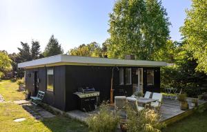 une petite maison noire avec une table de pique-nique et un barbecue dans l'établissement Gorgeous Home In Højby With Wifi, à Højby 13 autres photos