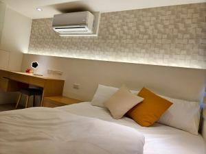 a bedroom with a white bed with two pillows at 大吉子溫泉民宿 in Yü-shih-ts'un