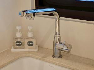 a sink with a faucet and two soap bottles at 大吉子溫泉民宿 in Yü-shih-ts'un