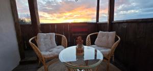 a balcony with a glass table and two chairs at Вили Панорама Лещен in Leshten
