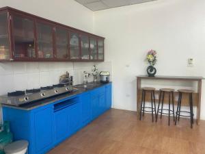 una cucina con armadi blu e sgabelli da bar di Villa 407 Eureka resort Linh Trường a Thanh Hóa