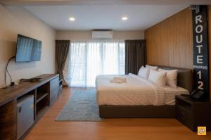 Ban Huai HiaにあるRoute12のベッドとテレビがあるホテルの部屋