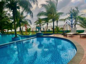 una grande piscina con palme in un resort di Villa 407 Eureka resort Linh Trường a Thanh Hóa