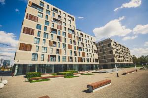 a large building with benches in front of it at GO Apartments in Warsaw