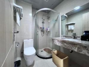 a bathroom with a shower and a toilet and a sink at Bashan Hotel in Xiamen +201 photos