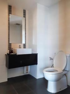 a bathroom with a white toilet and a sink at The Living-Hills in Chiang Mai
