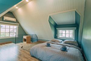 a bedroom with a large bed and two windows at Khaoyai Art Tree in Pong Talong +216 photos